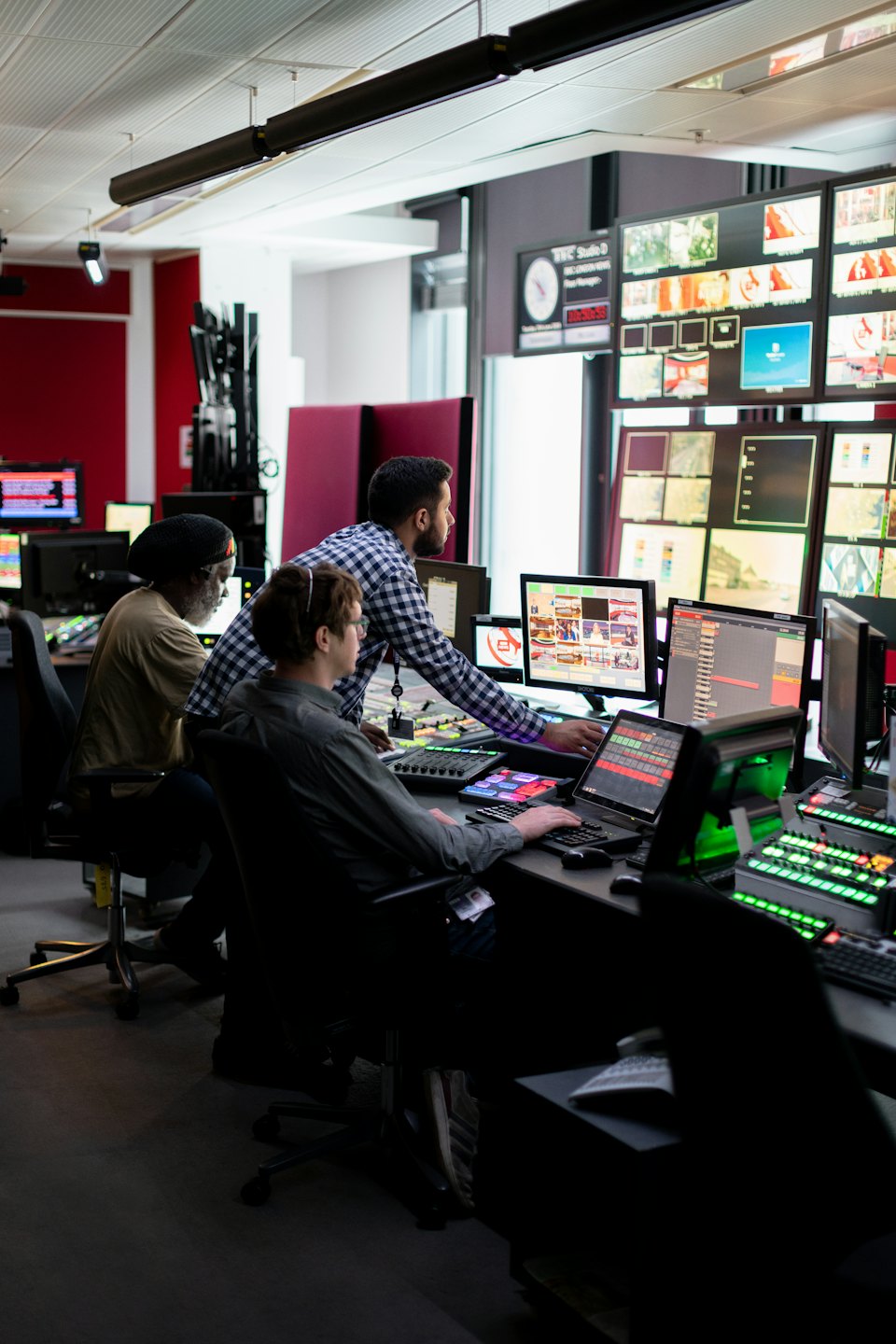 Media professionals collaborating in a busy broadcast control room.